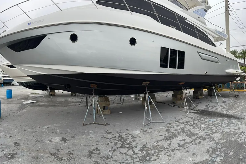  Yacht Photos Pics 2014 Azimut 54 yacht on dry dock, supported by stands, showcasing sleek design.