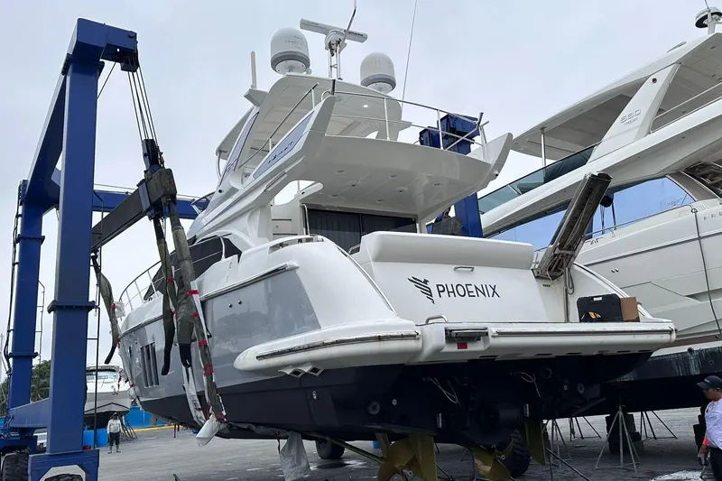  Yacht Photos Pics 2014 Azimut 54 yacht named Phoenix on a lift at a marina.