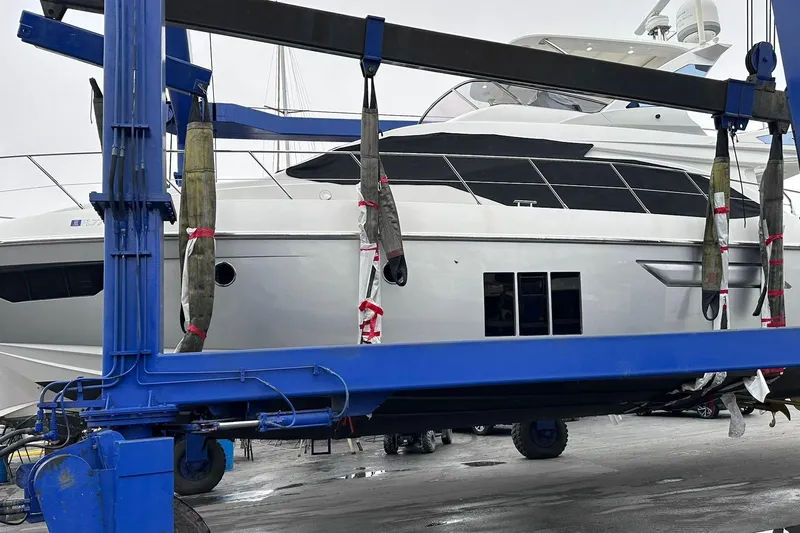  Yacht Photos Pics 2014 Azimut 54 yacht being lifted by a blue crane at a dock.