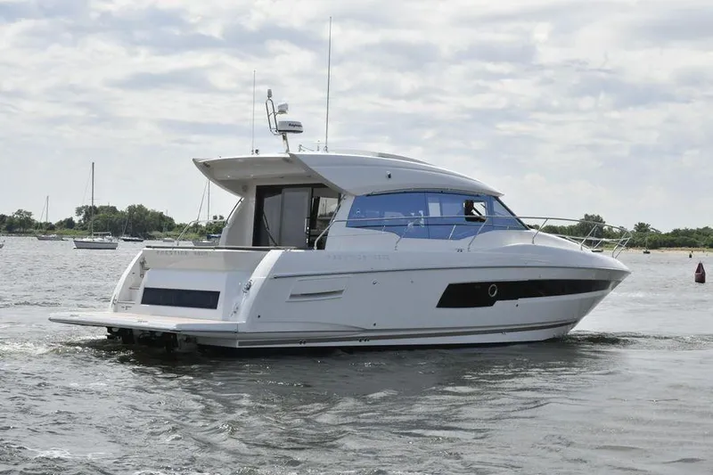  Yacht Photos Pics 2019 Prestige 460 yacht cruising on a calm waterway under a cloudy sky.