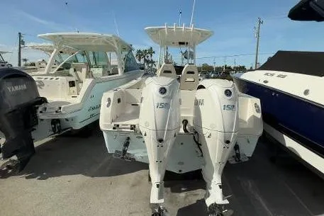 242-935 Yacht Photos Pics 2024 Sailfish 242 CC boat with dual Yamaha engines, docked outdoors.