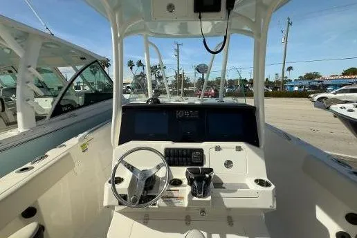 242-935 Yacht Photos Pics 2024 Sailfish 242 CC boat cockpit with steering wheel and control panel.