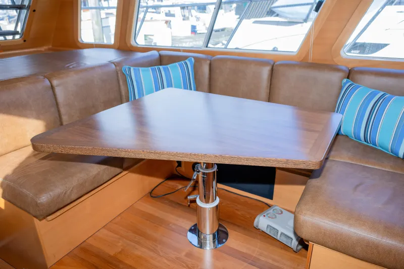 Alki Yacht Photos Pics Luxurious interior of 2013 Coastal Craft 45 yacht with wooden table and leather seating.