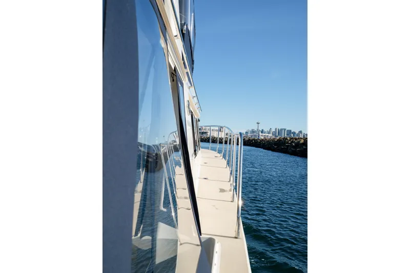 Alki Yacht Photos Pics Side view of 2013 Coastal Craft 45 yacht on water with city skyline in background.