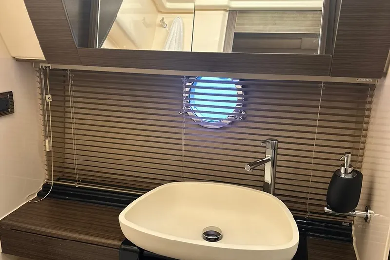 Encore Yacht Photos Pics Luxurious bathroom interior of 2015 Azimut 55S yacht with modern sink and porthole window.