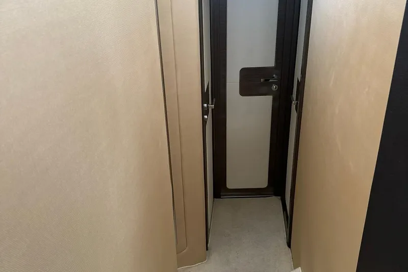 Encore Yacht Photos Pics Narrow hallway inside 2015 Azimut 55S yacht, featuring sleek modern design and wooden door.