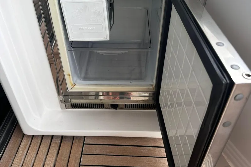 Encore Yacht Photos Pics Open ice maker on 2015 Azimut 55S yacht, showing interior and wooden deck.