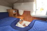 Interior cabin of 2007 Cranchi CSL 27 boat with blue seating and wood accents.