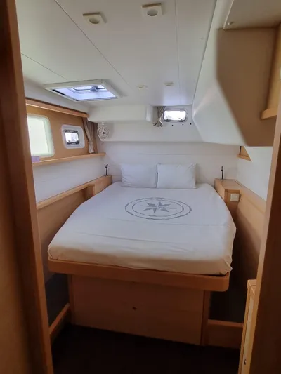 Fellowship Yacht Photos Pics Cozy cabin interior of 2017 Lagoon 450 F catamaran with double bed and porthole windows.