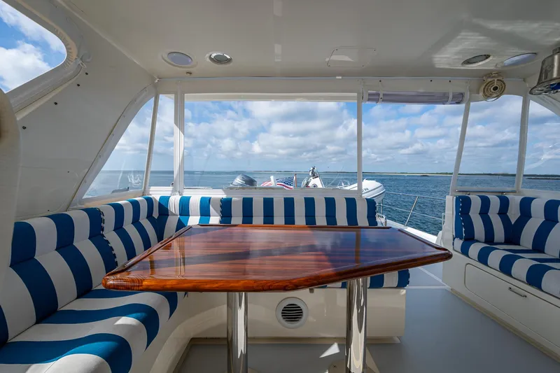 Cara Mia Yacht Photos Pics Interior of 2021 Marlow 53E Explorer yacht with striped seating and wooden table.