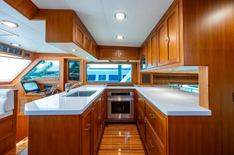 Cara Mia Yacht Photos Pics Luxurious kitchen interior of 2021 Marlow 53E Explorer yacht with wooden cabinetry and modern appliances.