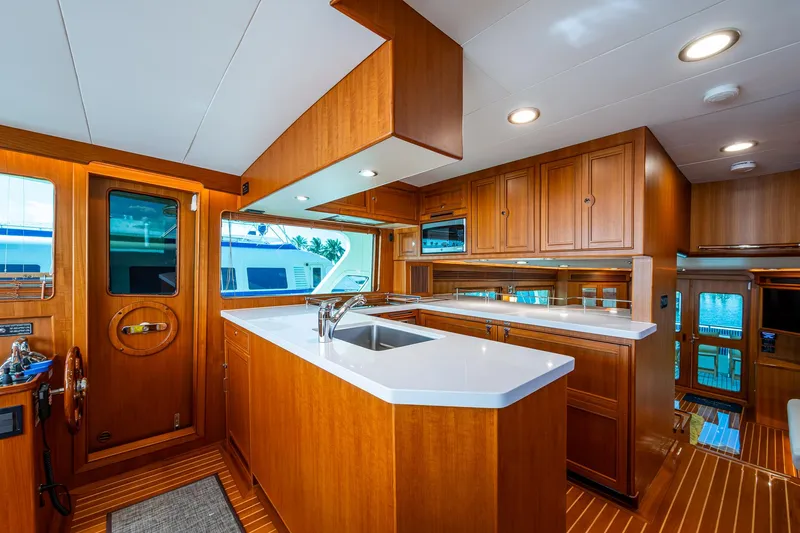 Cara Mia Yacht Photos Pics Luxurious kitchen interior of 2021 Marlow 53E Explorer yacht with wooden cabinetry and modern fixtures.