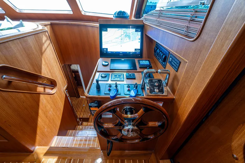 Cara Mia Yacht Photos Pics Pilothouse of 2021 Marlow 53E Explorer yacht with navigation controls and wooden steering wheel.