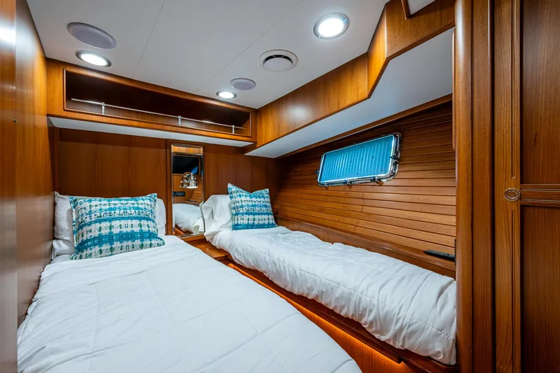 Cara Mia Yacht Photos Pics Twin cabin interior of 2021 Marlow 53E Explorer yacht with wooden finish and cozy bedding.