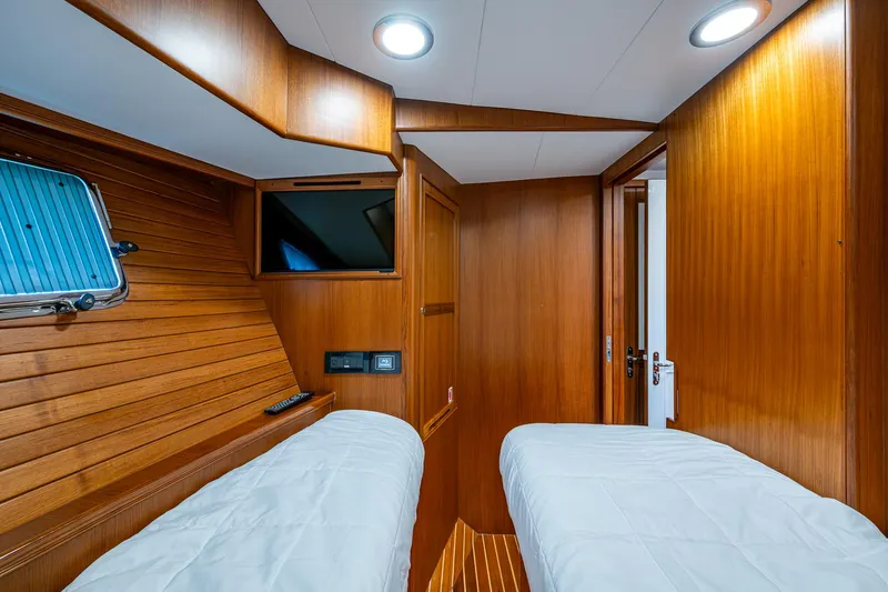 Cara Mia Yacht Photos Pics Cabin interior of 2021 Marlow 53E Explorer yacht with twin beds and wooden paneling.