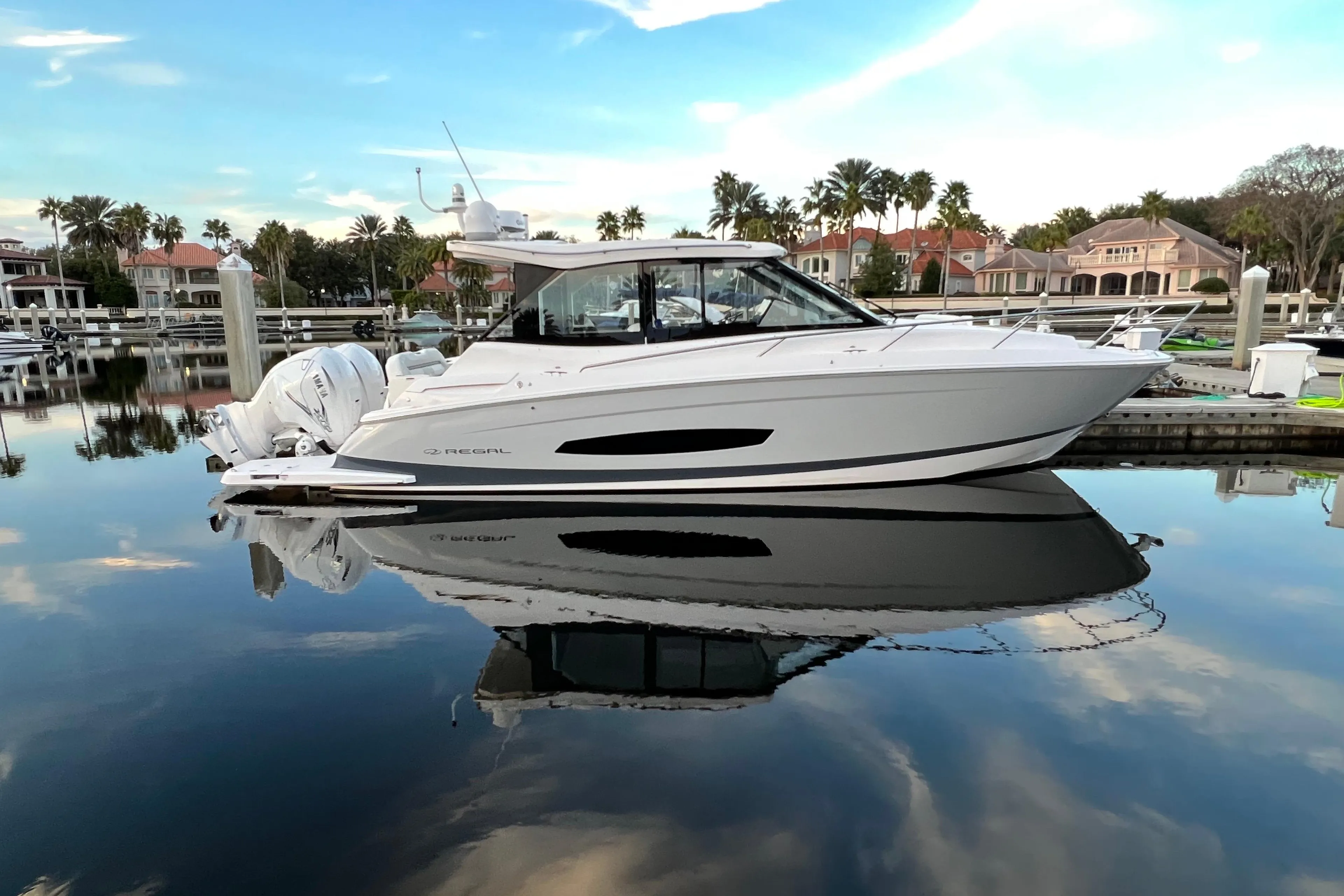 2021 Regal 36 XO boat docked in a serene marina, reflecting on calm water.