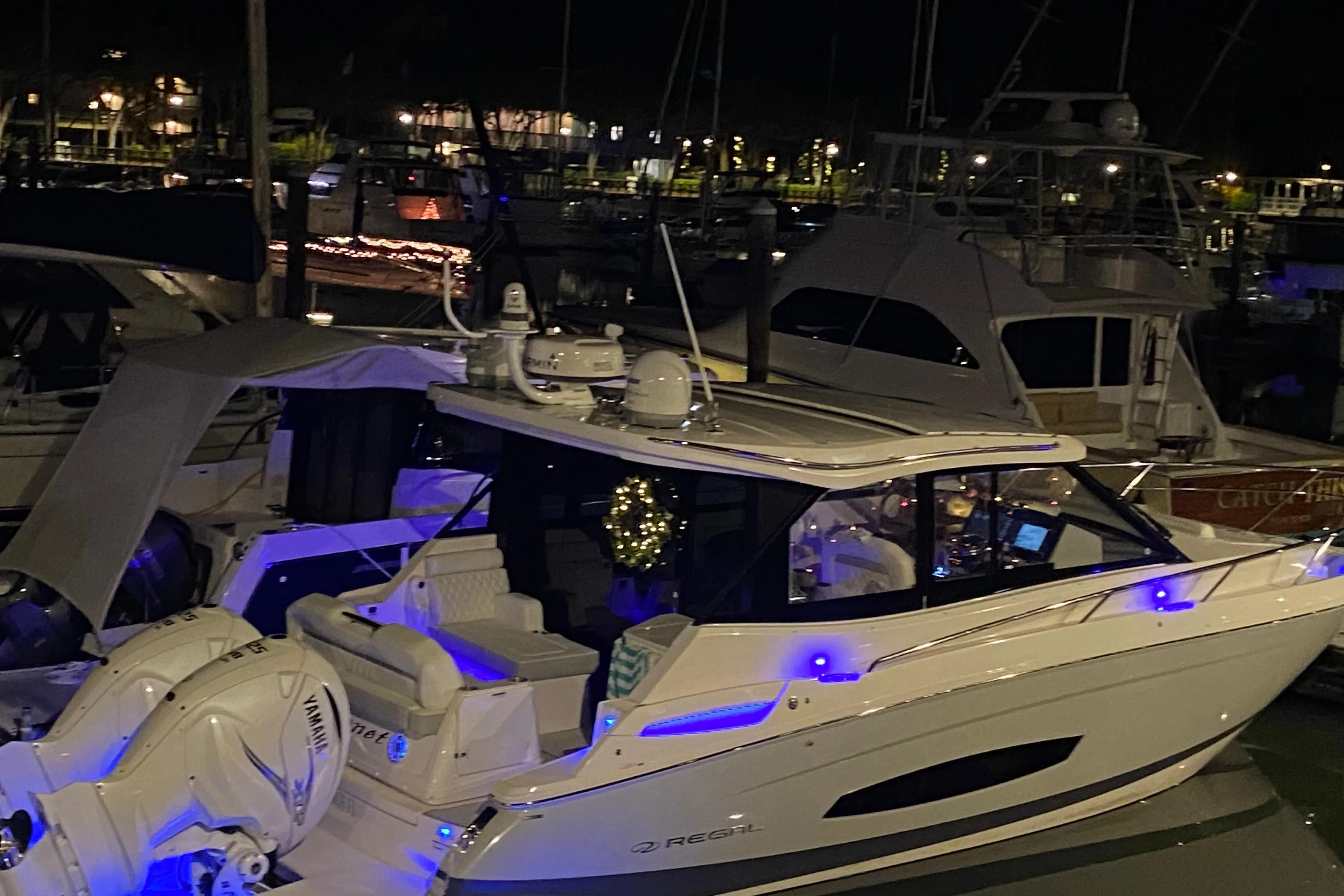 2021 Regal 36 XO yacht illuminated at night in a marina setting.
