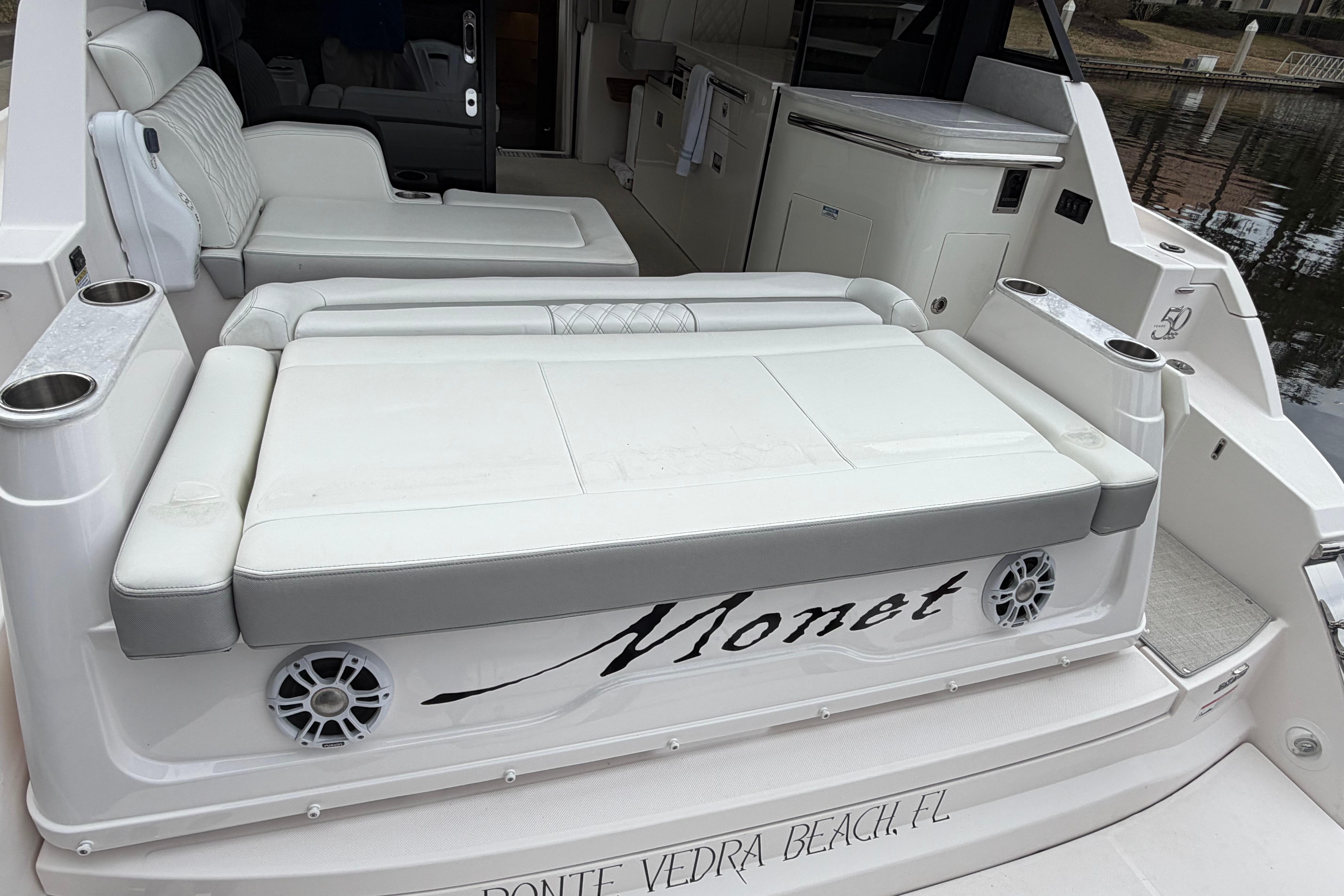 2021 Regal 36 XO yacht with white seating and cup holders, docked at Ponte Vedra Beach.