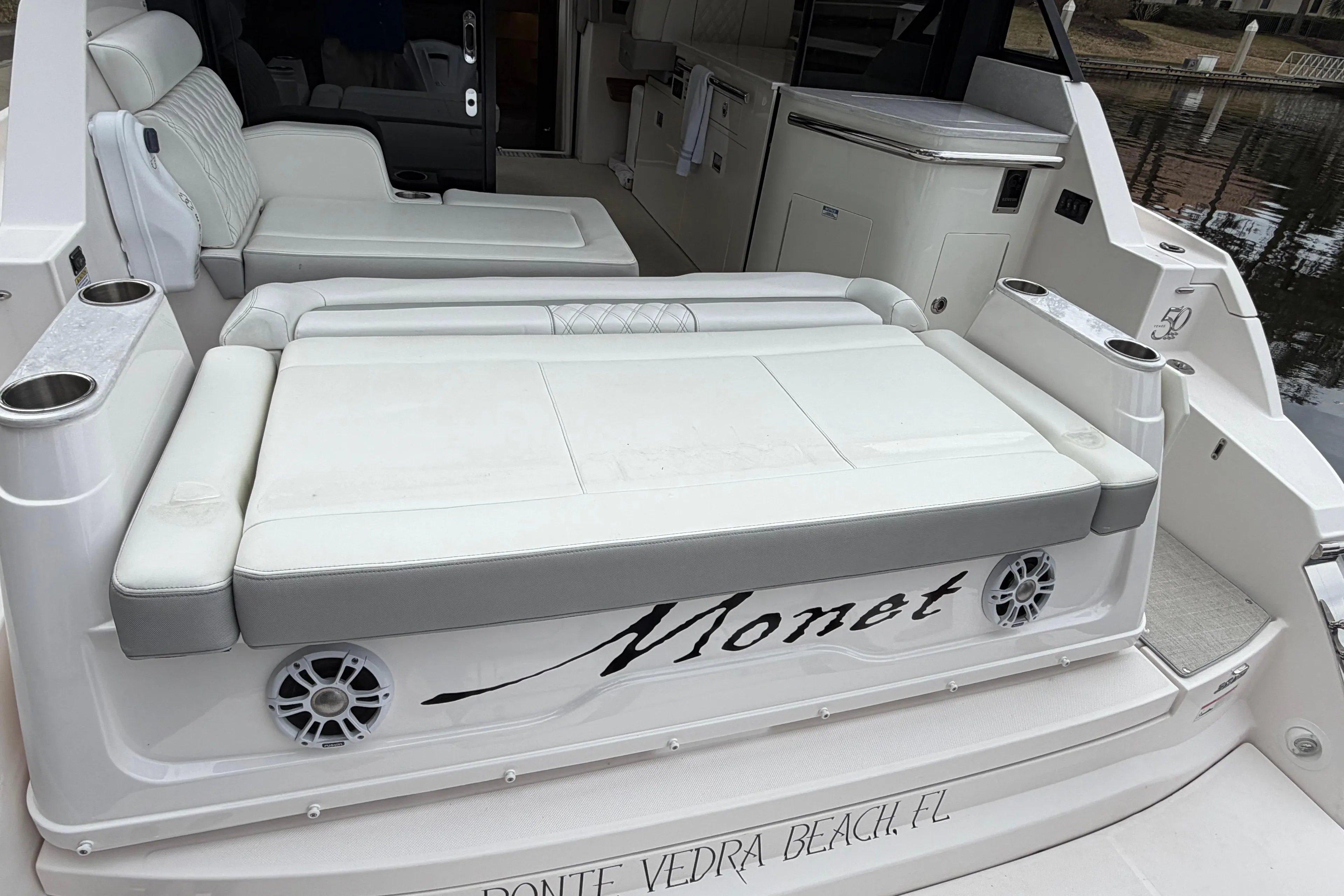 2021 Regal 36 XO yacht with white seating and cup holders, docked at Ponte Vedra Beach.