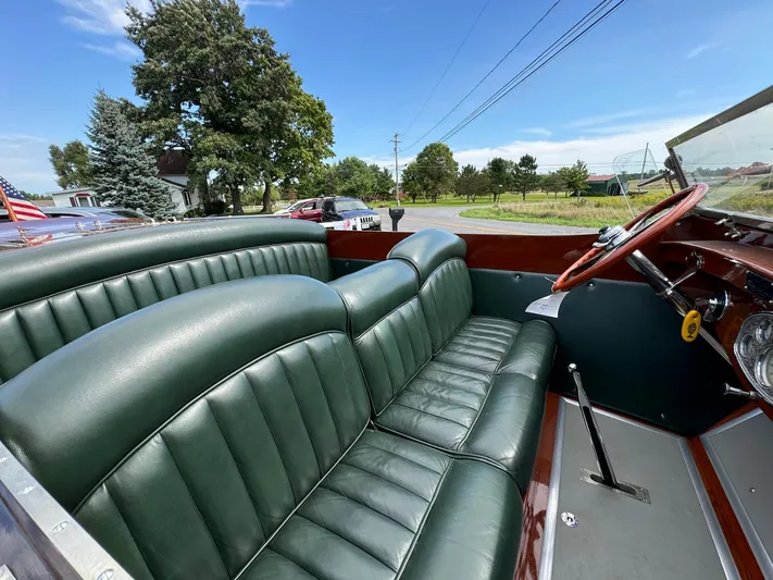 The Paragon Yacht Photos Pics 1929 Chris-Craft 26 Upswept Triple Cockpit with green leather seats and wooden dashboard.