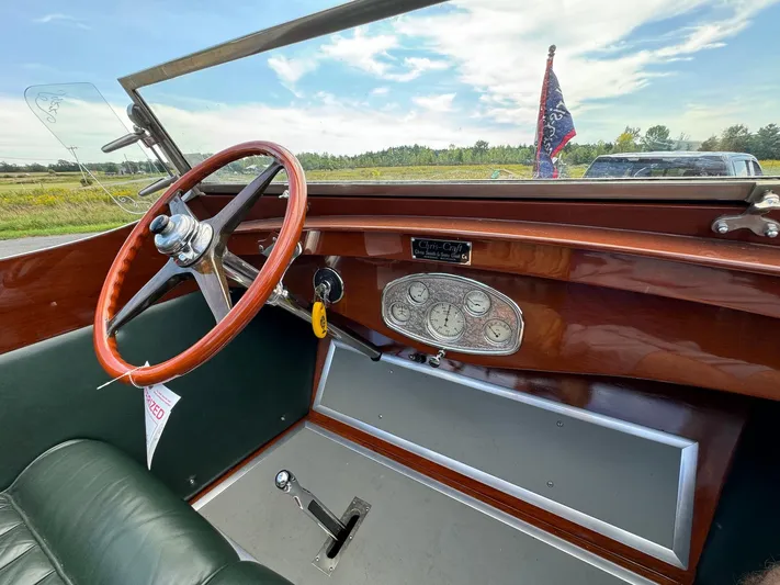 The Paragon Yacht Photos Pics 1929 Chris-Craft 26 Upswept Triple Cockpit interior with wooden dashboard and steering wheel.