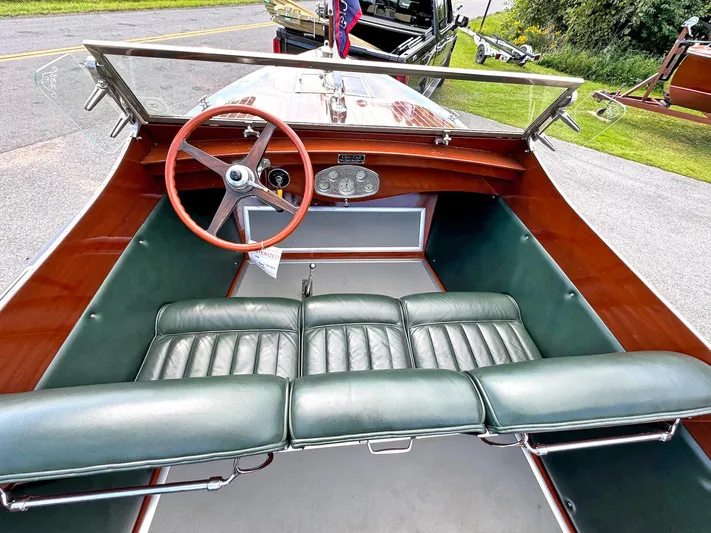 The Paragon Yacht Photos Pics 1929 Chris-Craft 26 Upswept Triple Cockpit with green leather seats and wooden steering wheel.