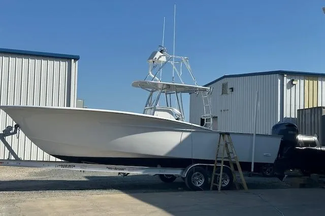  Yacht Photos Pics Custom Carolina Forbes 2025 boat on trailer near storage buildings.