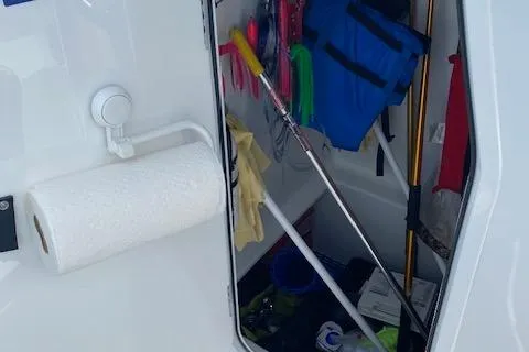  Yacht Photos Pics Storage compartment on 2025 Custom Carolina Forbes boat with cleaning supplies and life jackets.
