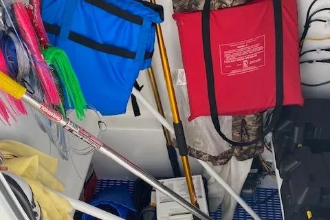  Yacht Photos Pics Storage area on a 2025 Custom Carolina Forbes boat with fishing gear and safety equipment.