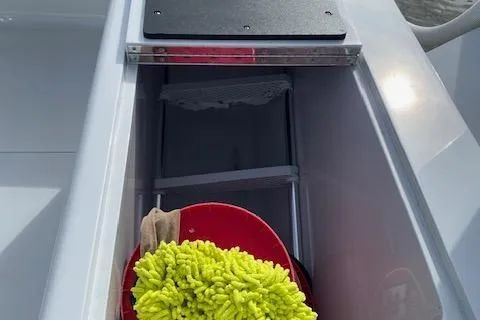  Yacht Photos Pics Storage compartment on 2025 Custom Carolina Forbes boat with cleaning supplies.
