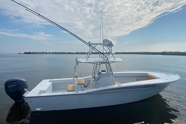  Yacht Photos Pics 2025 Custom Carolina Forbes boat on calm water under a partly cloudy sky.