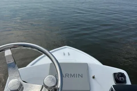  Yacht Photos Pics Steering wheel view on 2025 Custom Carolina Forbes boat, Garmin navigation, calm waters.