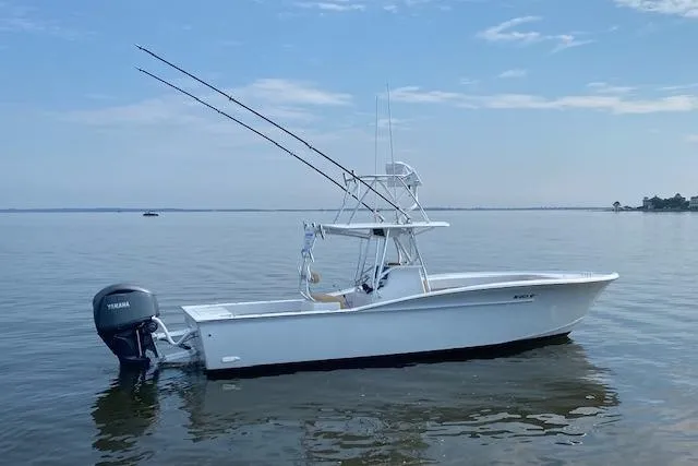  Yacht Photos Pics Custom Carolina Forbes 2025 boat on calm water with fishing rods and Yamaha engine.