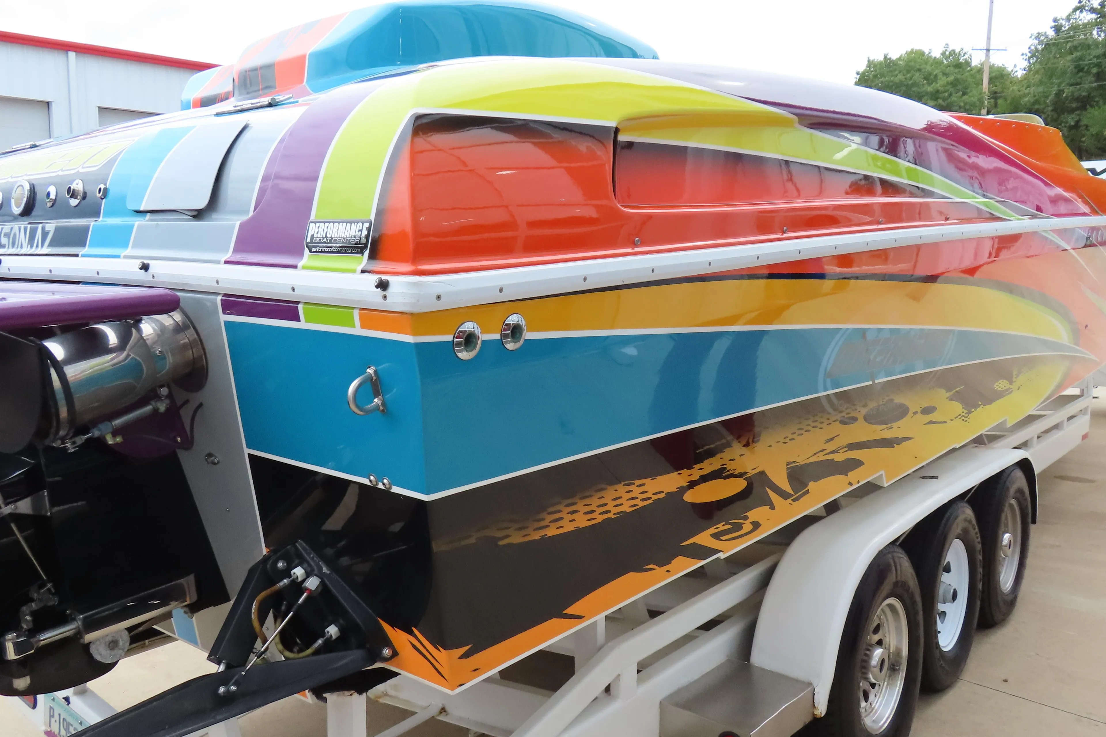 Colorful 2001 Outerlimits 42 Legacy speedboat on trailer, showcasing vibrant custom paint design.