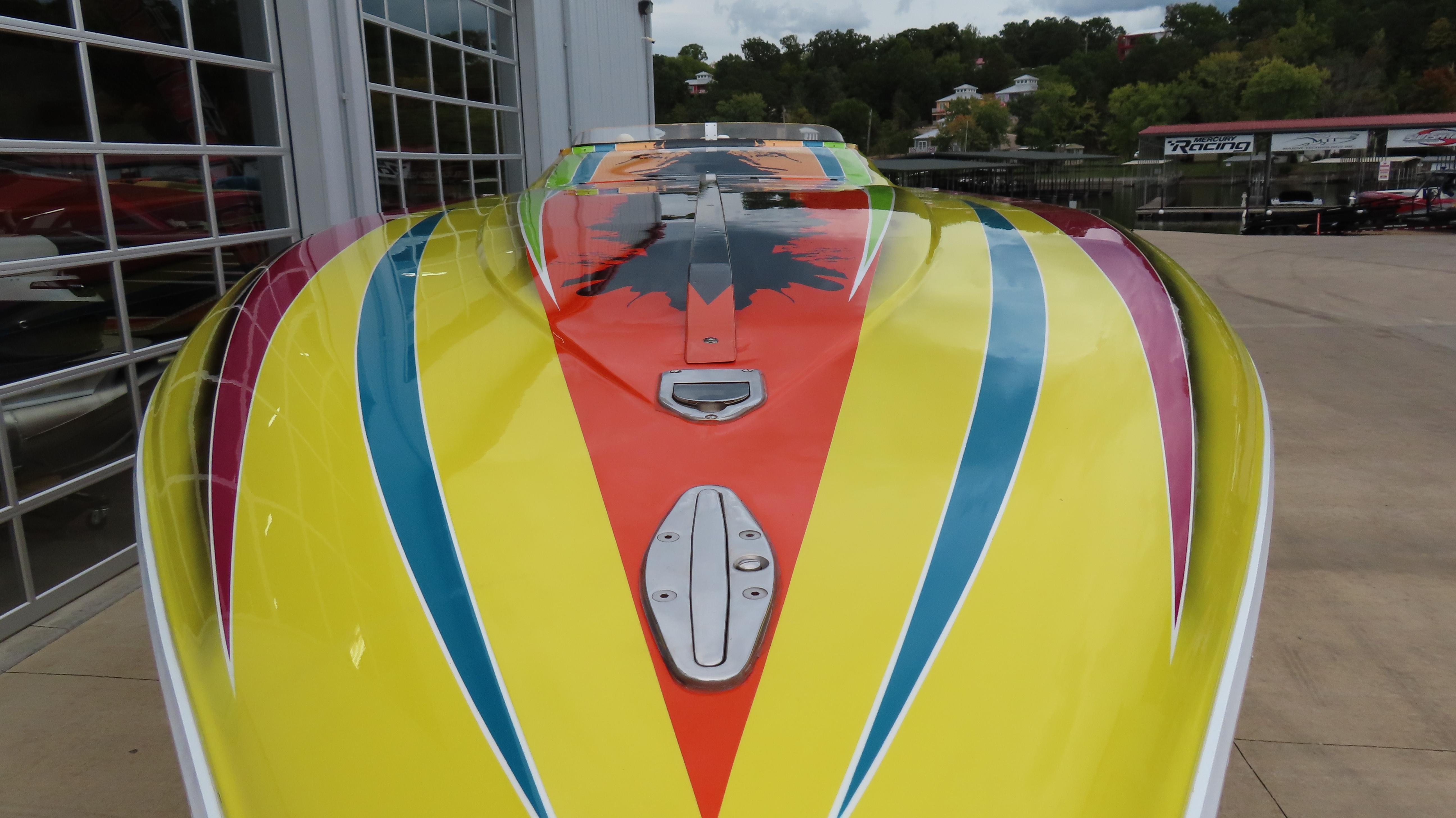 2001 Outerlimits 42 Legacy boat with vibrant yellow, red, and blue design.