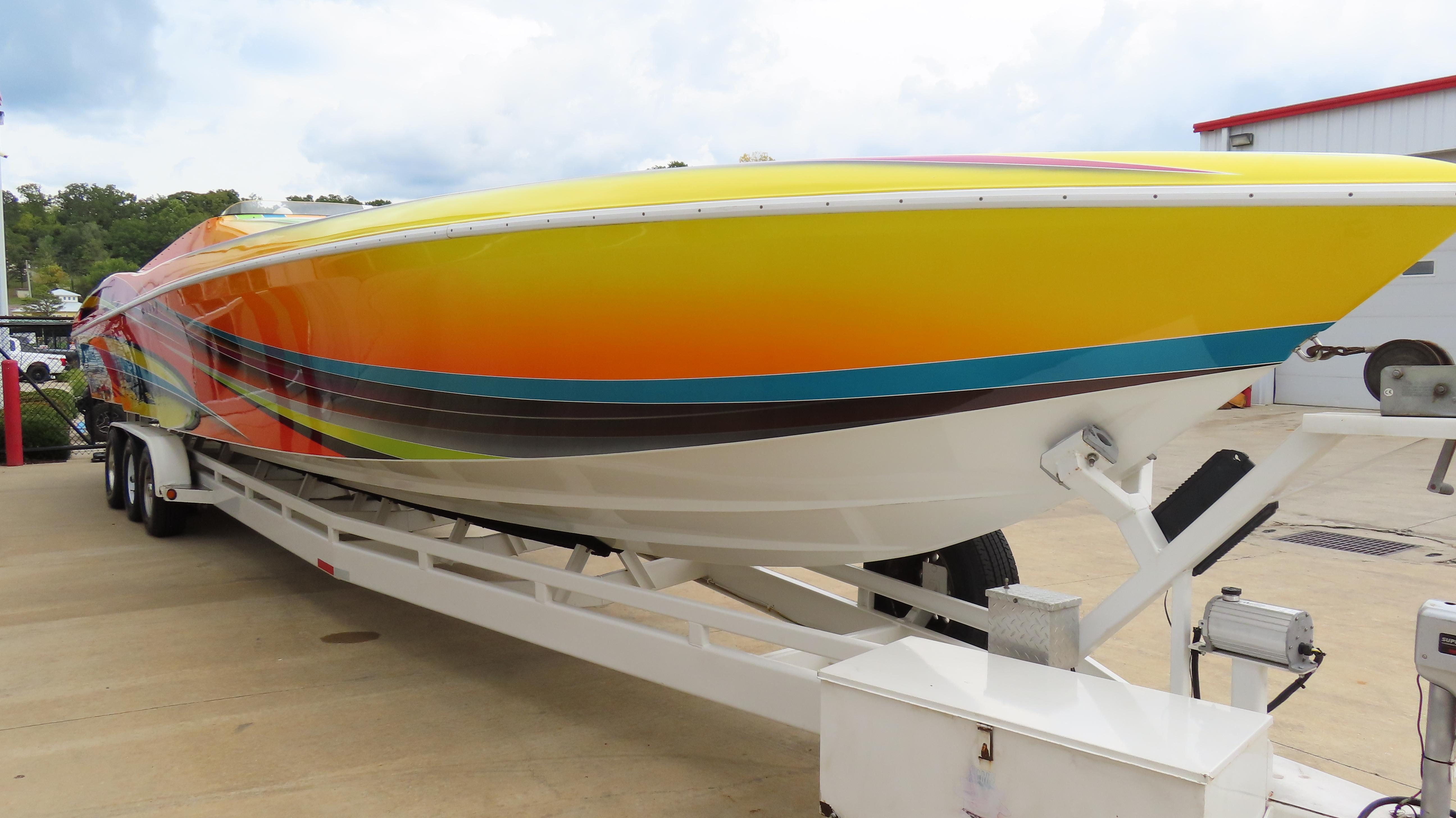2001 Outerlimits 42 Legacy speedboat with vibrant, colorful design on a trailer.