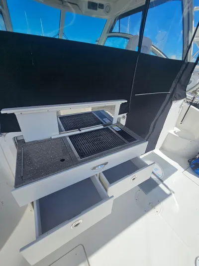  Yacht Photos Pics 2013 Boston Whaler 315 Conquest boat interior with open storage drawers and grill.