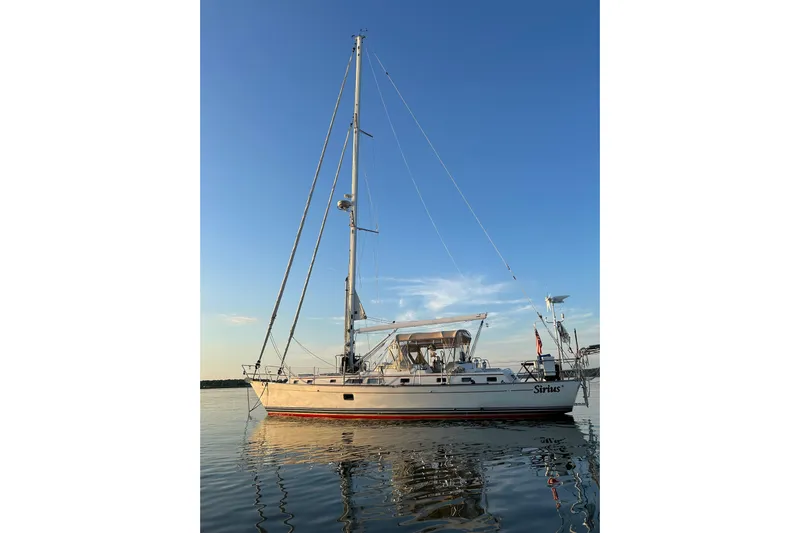 Sirius Yacht Photos Pics Sailing yacht Passport 470 Center Cockpit 2011 on calm water at sunset.