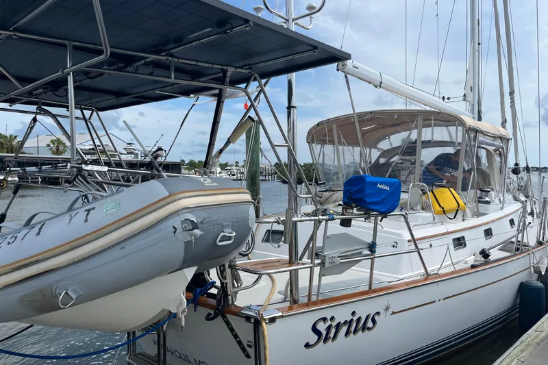 Sirius Yacht Photos Pics Passport 470 Center Cockpit sailboat docked, featuring a dinghy and solar panels, 2011 model.