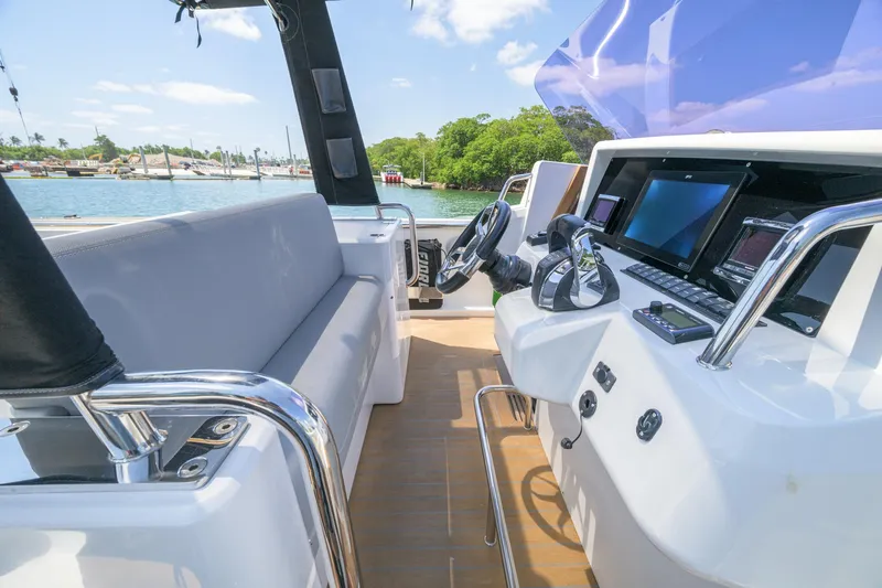  Yacht Photos Pics 2018 Fjord 36 Xpress boat interior with modern dashboard and seating, docked by the water.