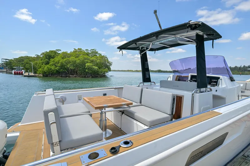  Yacht Photos Pics 2018 Fjord 36 Xpress yacht with spacious seating, docked near lush island.