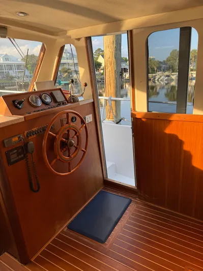  Yacht Photos Pics 2000 Mainship 390 Trawler helm with wooden steering wheel and scenic marina view.