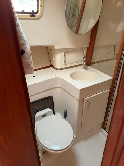 Yacht Photos Pics 2000 Mainship 390 Trawler bathroom with toilet, sink, and mirror.