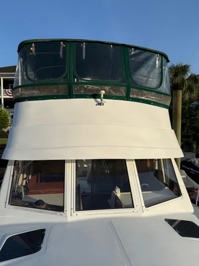  Yacht Photos Pics 2000 Mainship 390 Trawler with green canopy, docked under clear blue sky.