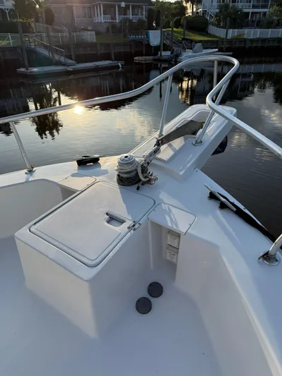  Yacht Photos Pics 2000 Mainship 390 Trawler bow with railing, winch, and storage compartment at sunset.