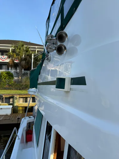  Yacht Photos Pics 2000 Mainship 390 Trawler docked, showcasing sleek white exterior and green accents.