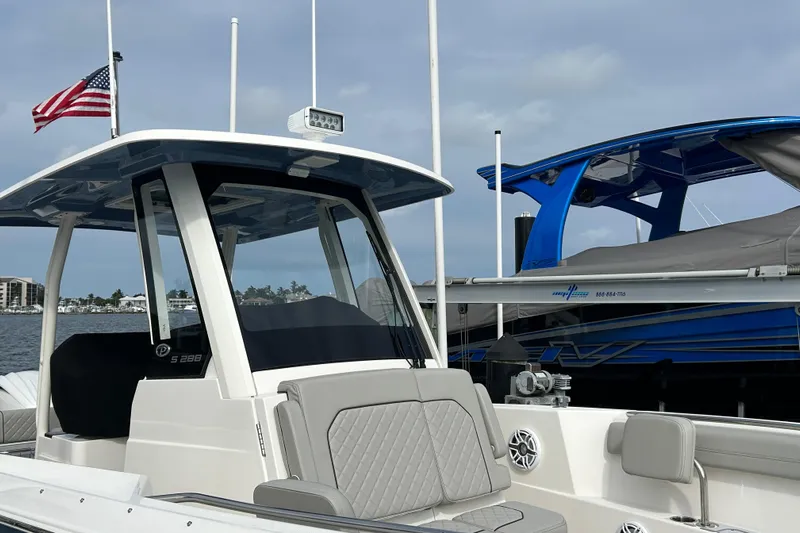  Yacht Photos Pics 2023 Pursuit S 288 Sport boat docked, featuring sleek design and American flag.