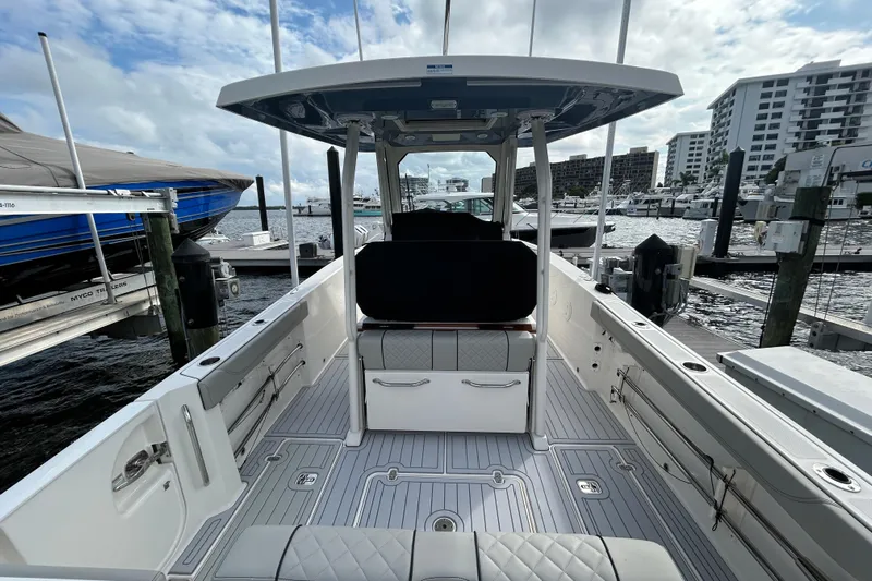  Yacht Photos Pics 2023 Pursuit S 288 Sport boat interior at marina, showcasing seating and deck layout.