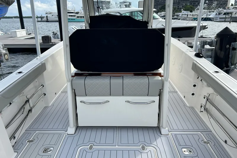  Yacht Photos Pics 2023 Pursuit S 288 Sport boat interior at marina, featuring sleek seating and modern design.