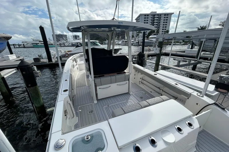  Yacht Photos Pics 2023 Pursuit S 288 Sport boat docked at marina, showcasing spacious deck and seating.